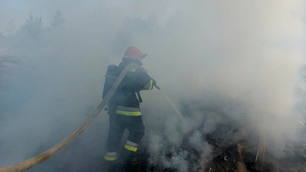 Рятувальники гасять загоряння сміття.
