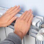 У Рівному планують завершити опалювальний сезон і залишити гарячу воду Жінка тримає руки на радіаторі.