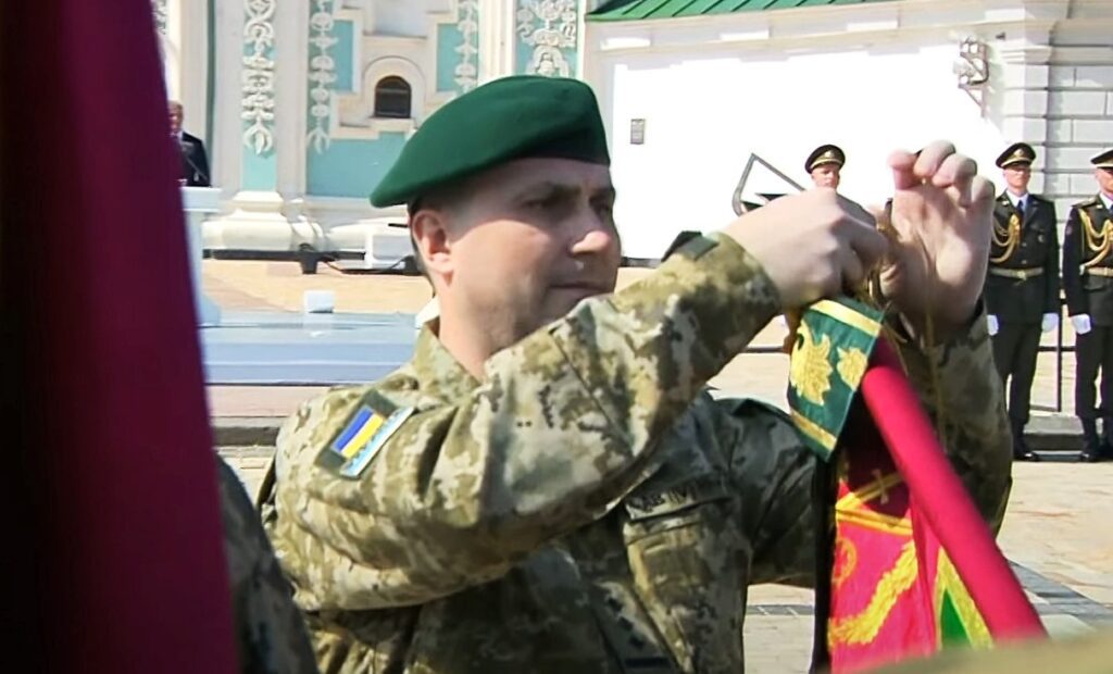 Полковник Антон Квятковський прикріплює відзнаку до бойового прапора.