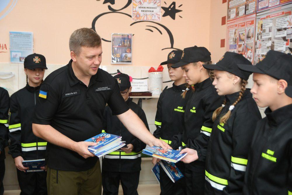 Начальник Рівненської ОВА Віталій Коваль роздає учням книжки.