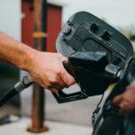 Чоловік заправляє авто.