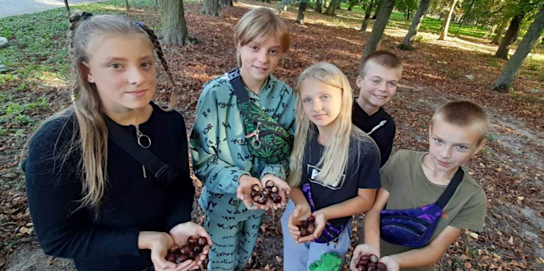 Діти тучинської школи збирають каштани.