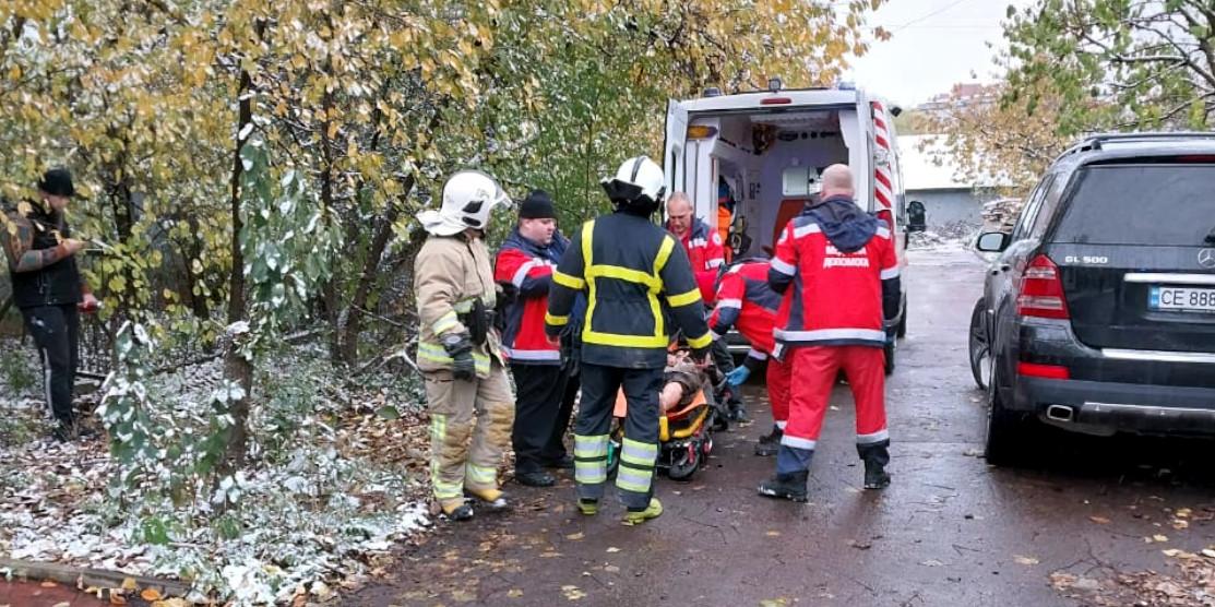 Рятувальники надають допомогу літній жінці.