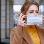 Жінка надягає маску.