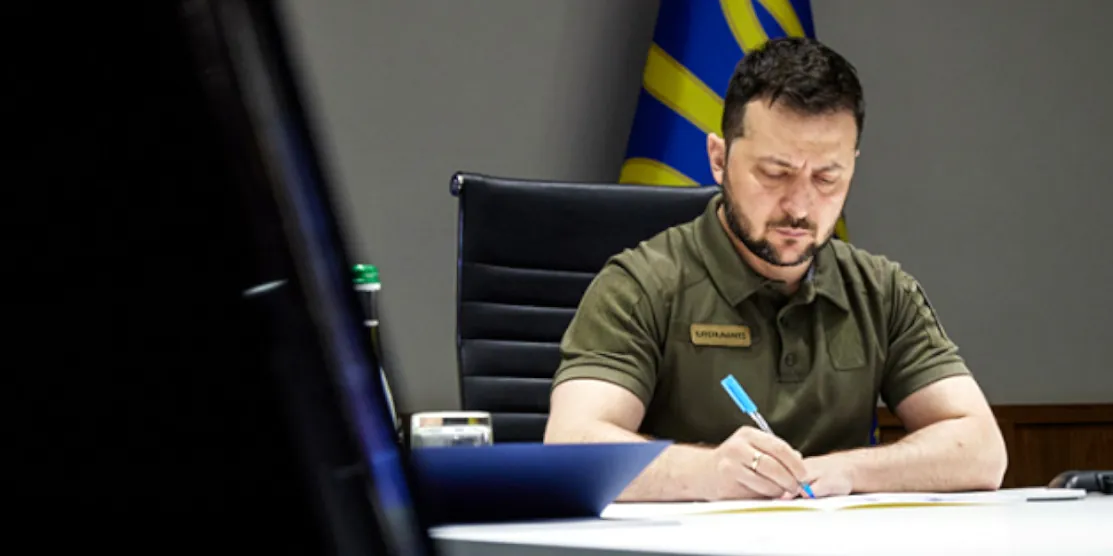 Володимир Зеленський підписує документ.