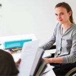 Робота для тисяч людей. Служба зайнятості Рівненщини підсумувала результати 2025 року Жінка в кріслі колісному працює за столом.