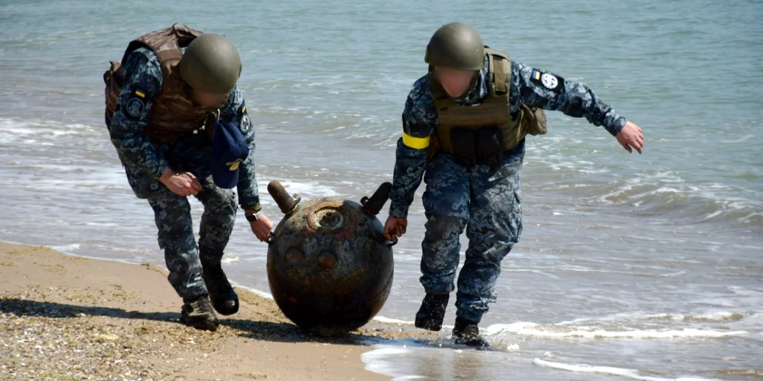 Військові несуть морську міну.