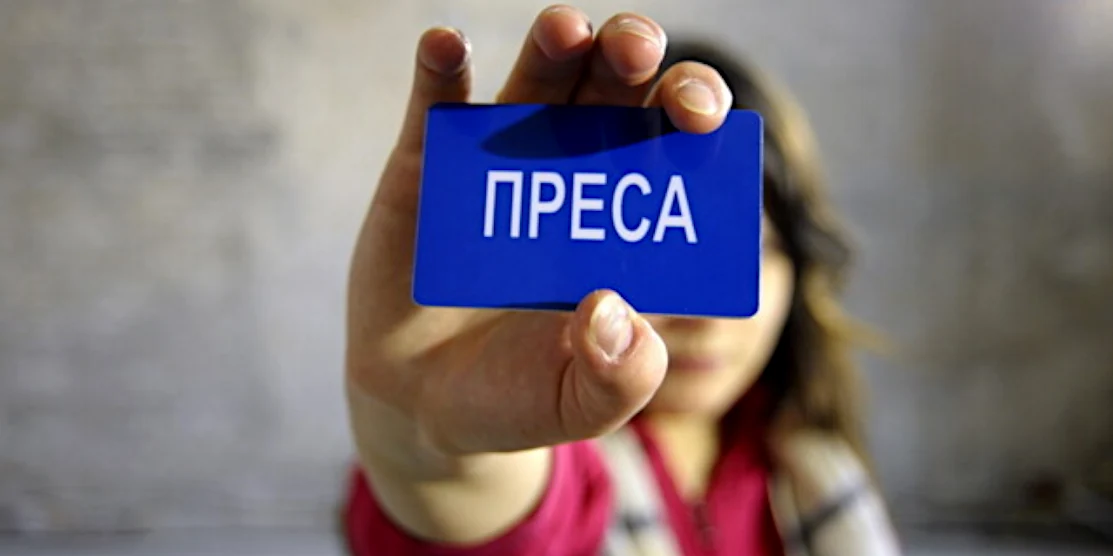 Жінка показує напис "Преса".