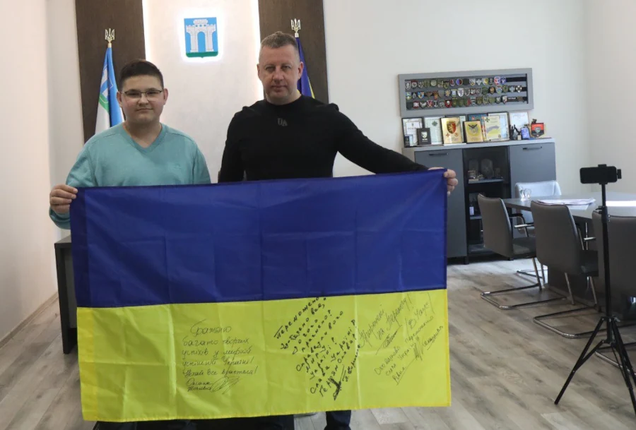 Кирило Передрій і Віктор Шакирзян позують з прапором.