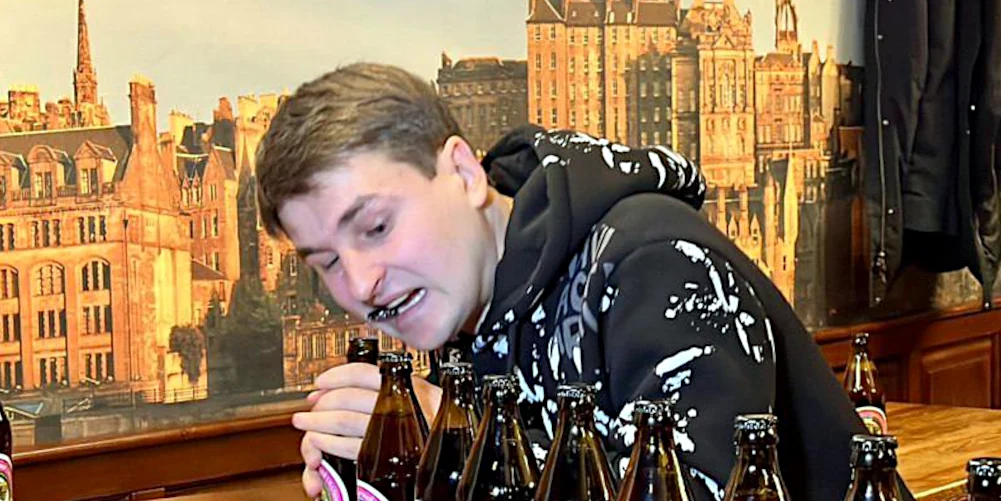 Олексій Кордзіховський відкриває пляшку зубами.