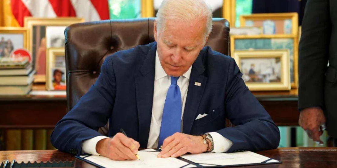 Президент США підписує документ.
