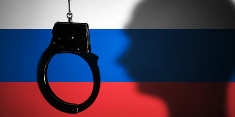 російський прапор, кайданки й тінь путіна.