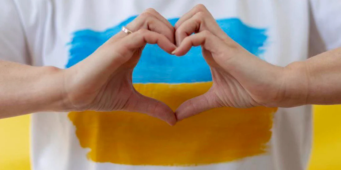 Сьогодні — День вдячності волонтерам Руки показують серце на фоні українського прапора.