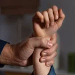 Чоловіча рука тримає дитячу руку за зап'ястя.