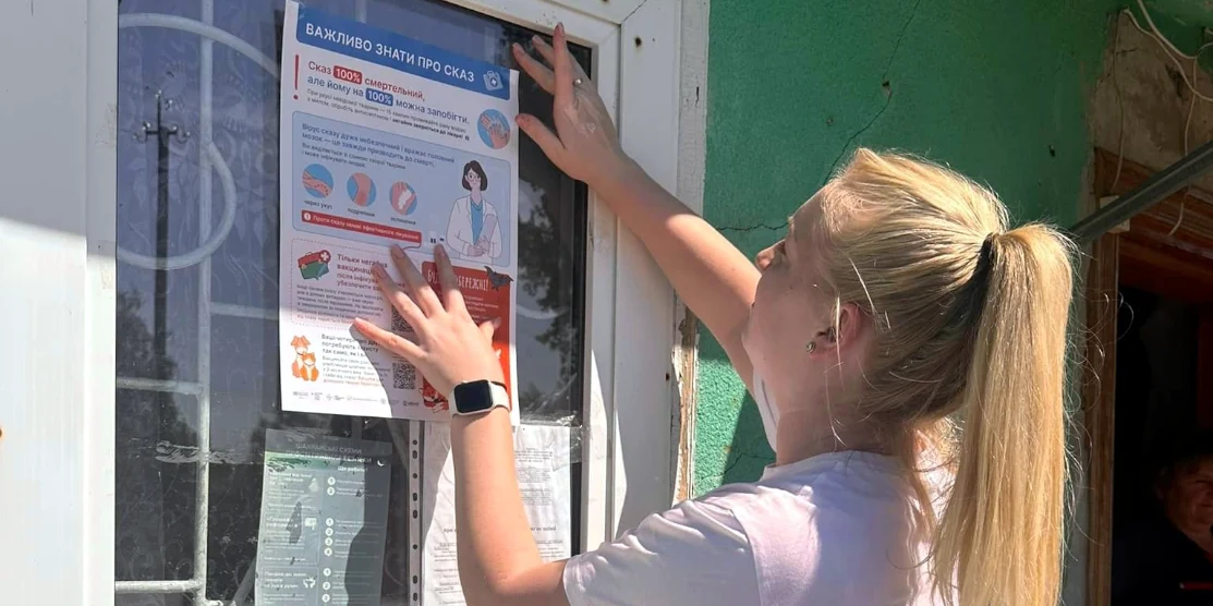 Працівниця Радивилівського структурного підрозділу ДУ «РО ЦКПХ МОЗ» розклеює листівки в селі Рідків з інформацією про сказ.