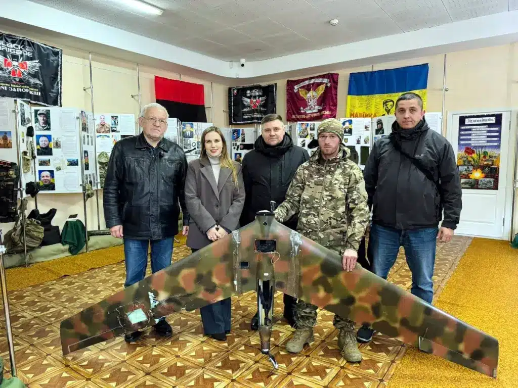 Михайло Снітчук передає уламки збитого російського безпілотника працівникам музею.
