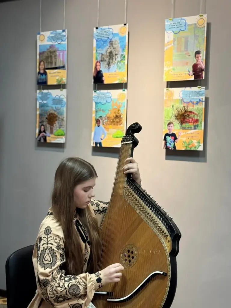 Грає бандуристка Катерина Власюк під час виставки "Херсон – шлях додому".