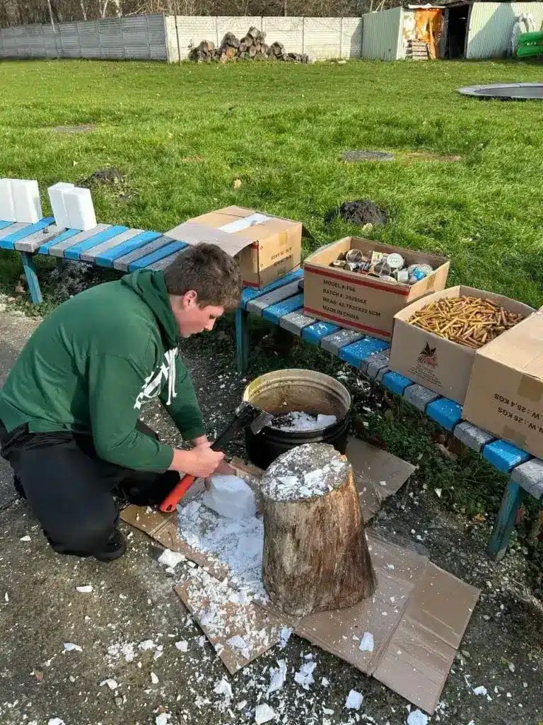 Пластун рубає сокирою парафін для окопних свічок.