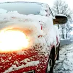 Обмерзле і в снігу авто на засніженій дорозі.