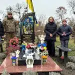 Мати полеглого захисника Павла Олійника і представники Нацгвардії його могилу.