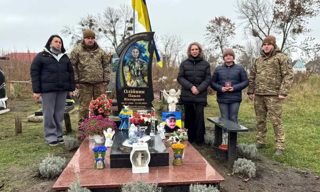Мати полеглого захисника Павла Олійника і представники Нацгвардії його могилу.