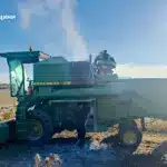 Рятувальник заливає з вогнегасника вогонь у моторному відсіці комбайна.