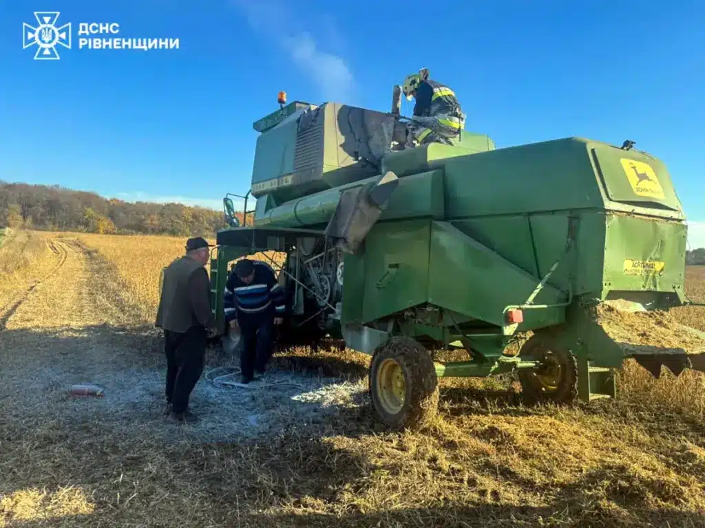Рятувальник гасить пожежу у моторному відсіці комбайна.