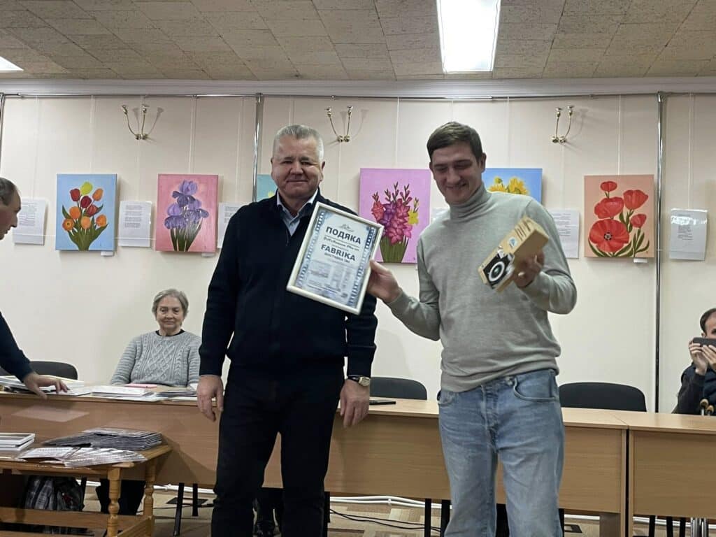 Богдан Гапяк вручає подяку та подарунок одному з учасників фотоконкурсу «ФеНоМенальне Рівне–2025»