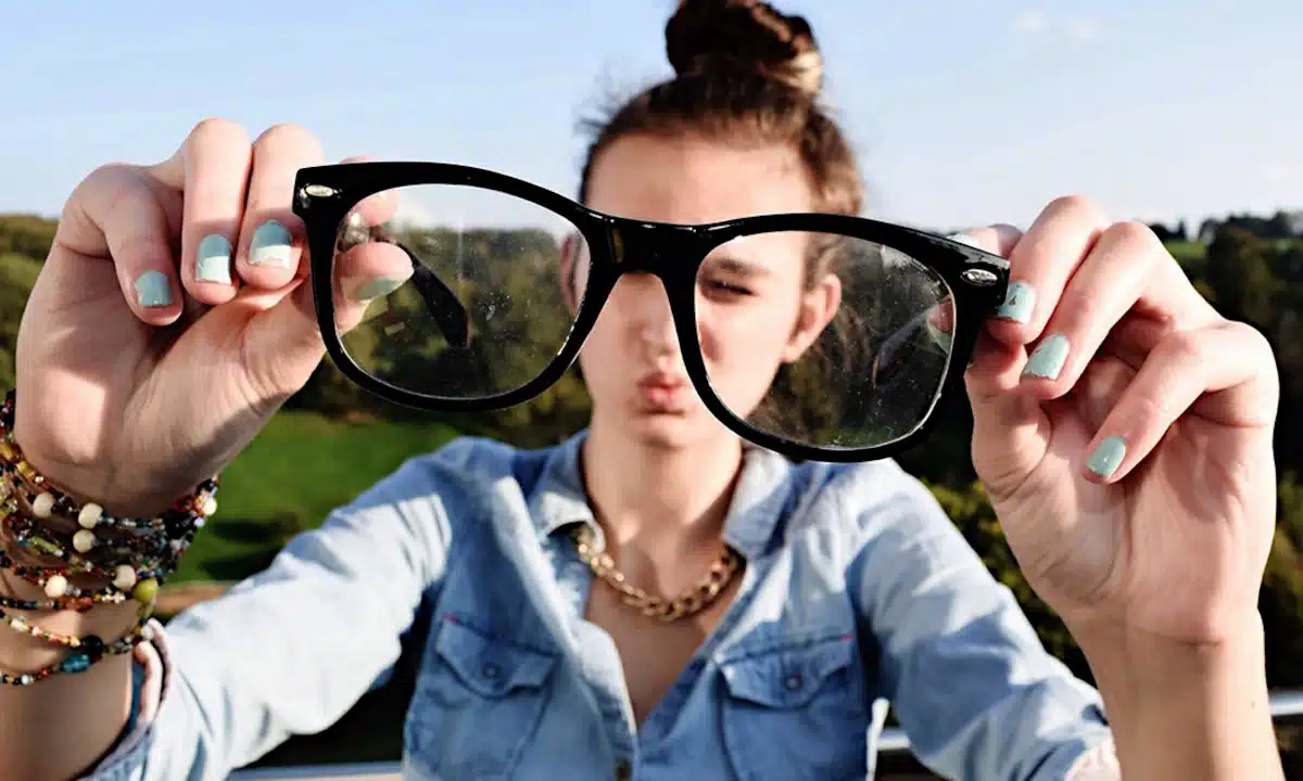 Як правильно чистити окуляри: прості поради для ідеальної чистоти та довговічності лінз Дівчина тримає брудні окуляри.