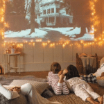 Фільми для новорічного настрою: що подивитися у святкові дні Сім’я з дітьми дивиться новорічний фільм удома: затишна кімната з ялинкою, гірляндами та святковою атмосферою.