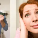 Жінка закриває вуха від звуків дрельки сусіда.