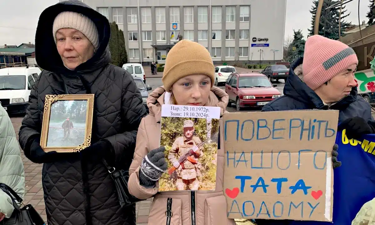 Мирна акція на підтримку військовополонених і зниклих безвісти відбулася у Корці Дівчинка тримає портрет батька і плакат під час акції у Корці.