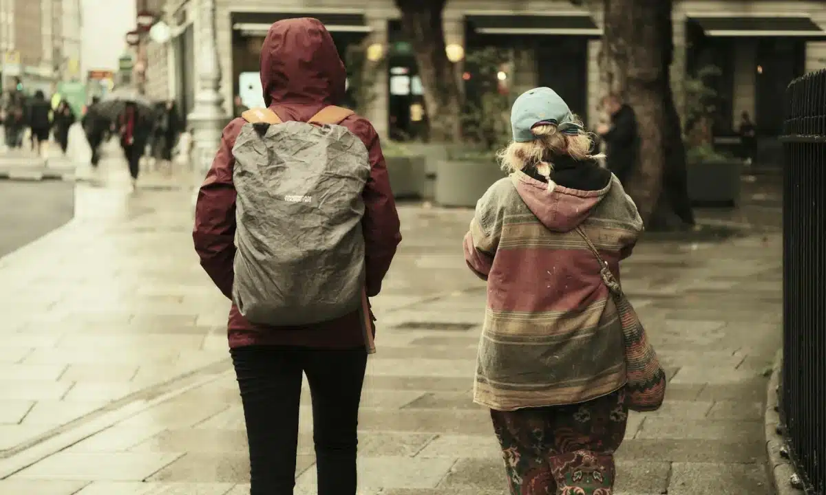 Двоє людей іде вулицею в дощ.