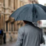 Якою буде погода на Рівненщині 21 грудня – про всяк випадок, бажано мати з собою парасольку Чоловік з парасолею йде вулицею міста.