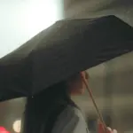 Якою буде погода на Рівненщині 12 грудня – синоптики радять брати з собою парасольки Жінка з парасолею в дощ.