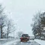 Якою буде погода на Рівненщині 28 грудня – ожеледиця й пориви вітру до 27 м/с Авто минає перехожу в червоній куртці по засніженій дорозі.