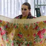 Доповідачка, тримаючи хустку, розповідає про давній український звичай носіння хусток.