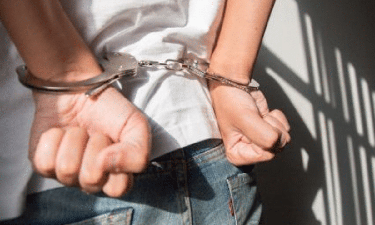 Затриманий чоловік у кайданках із руками за спиною