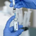 МОЗ оновило Календар щеплень: з 2026 року в Україні ширше застосовуватимуть комбіновані вакцини Медсестра набирає вакцину у шприц.