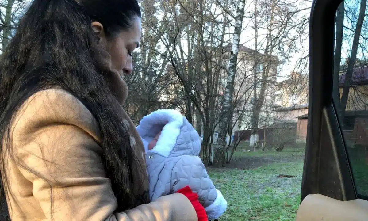 Представниця соцслужби із врятованим немовлям.