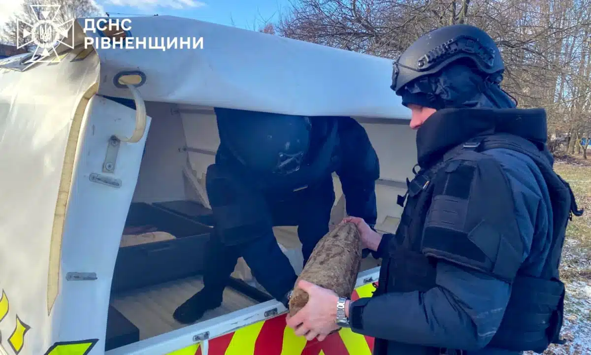 Піротехнік завантажує знайдений снаряд в авто.