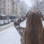 Що насправді відбувається з організмом, коли взимку ходити без шапки Жінка без шапки йде засніженою міською вулицею взимку