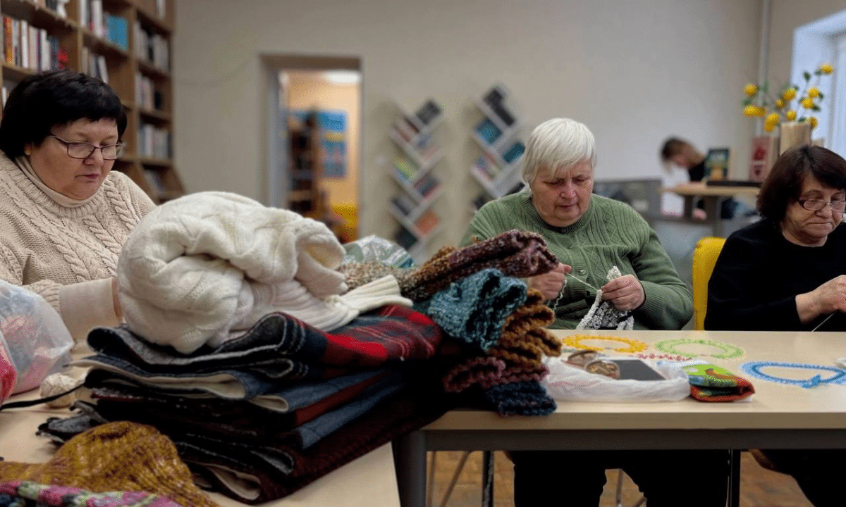 Жінки в'яжуть шкарпетки та пояси.