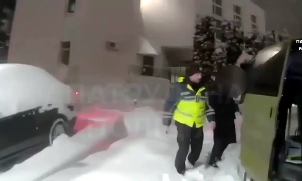 Патрульний допомагає жінці дійти до пологового відділення.