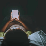 Жінка сидить в телефоні перед сном.