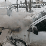 Рятувальник гасить вогонь в машині.