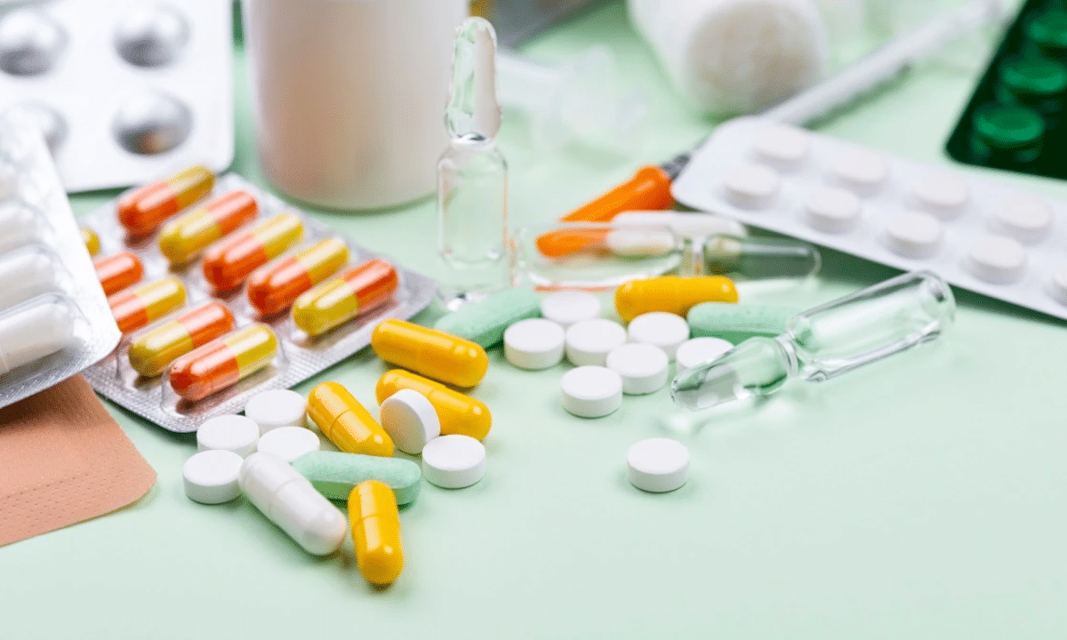 Різні лікарські засоби — таблетки, капсули та ампули розкладені на столі
