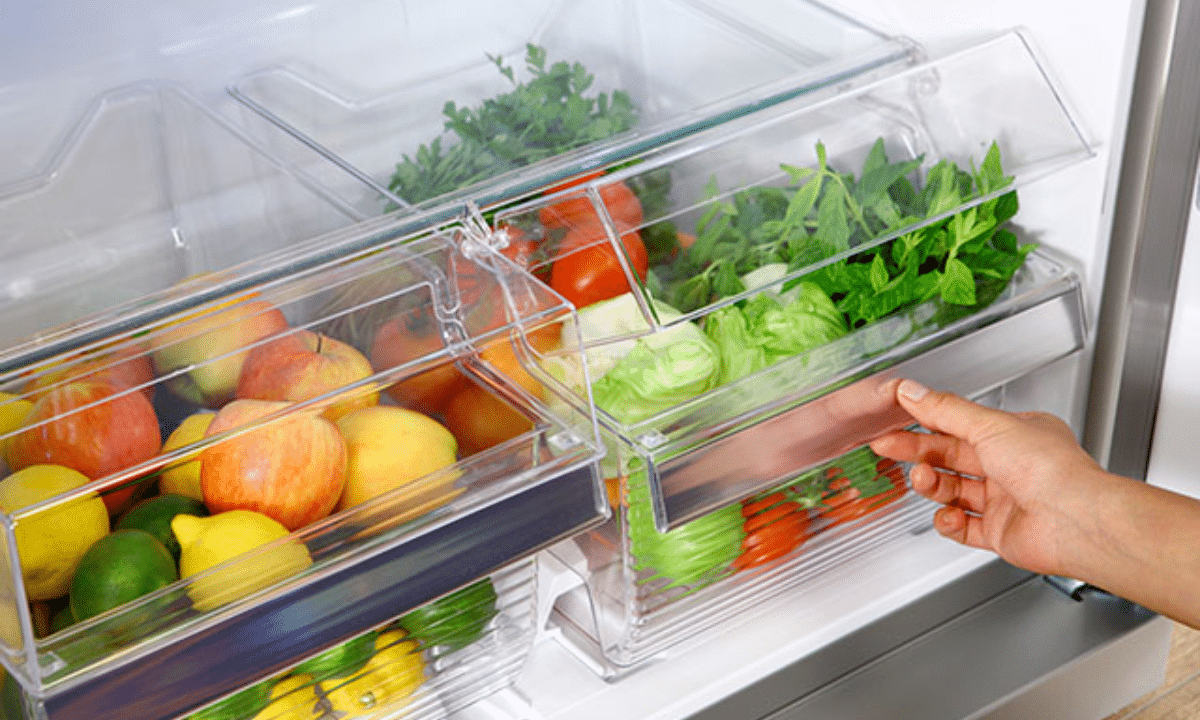 Овочі та фрукти в шухлядах холодильника.