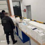Вилучені смартфони та інша техніка Apple, викладені на столах у приміщенні митного контролю