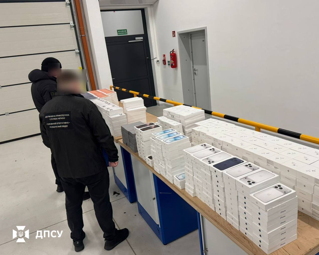 Вилучені смартфони та інша техніка Apple, викладені на столах у приміщенні митного контролю